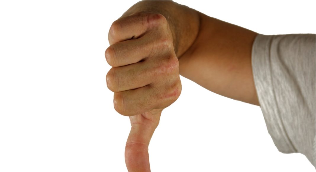 Палец вниз. Порицание. Отрицательная оценка. Изображение из фотобанка